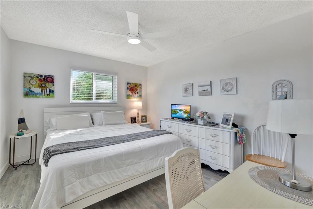 766 Central Avenue, Unit 303 Naples, FL 34102 - Photo 11 of 25 a bedroom with a bed and a dresser