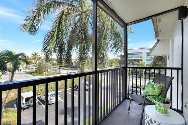 a view of a balcony with potted plants and palm tree