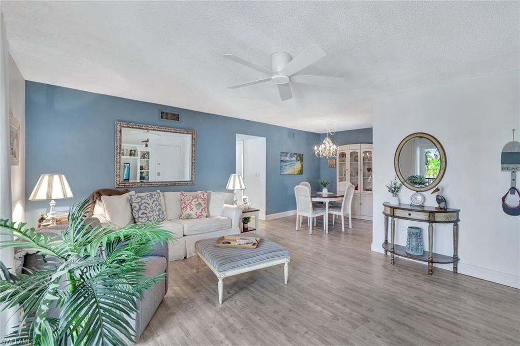 766 Central Avenue, Unit 303 Naples, FL 34102 - Photo 2 of 25 a living room with furniture a rug and a window