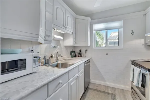 a kitchen with white cabinets and a sink