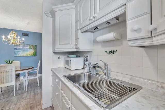 a kitchen with granite countertop a sink stove and cabinets