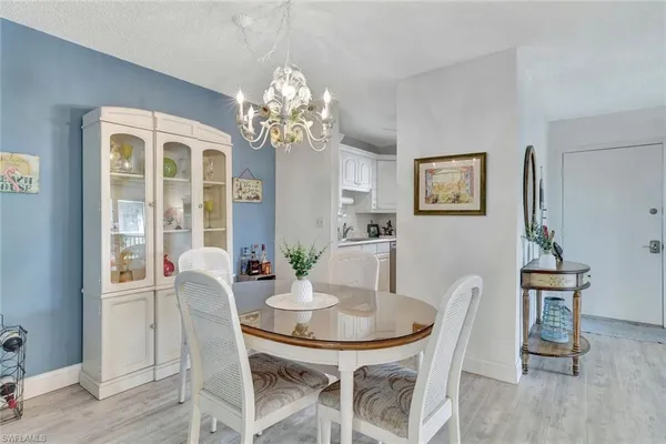 a view of a dining room with furniture a chandelier and wooden floor