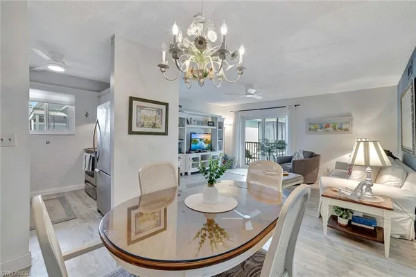 a view of a dining room with furniture a chandelier and wooden floor