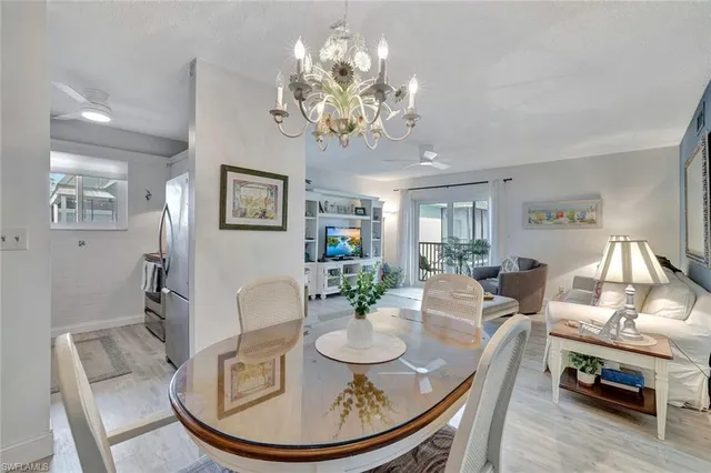 a view of a dining room with furniture a chandelier and wooden floor