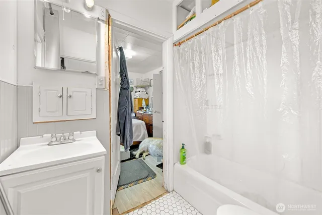 a bedroom with a bed and dresser with mirror