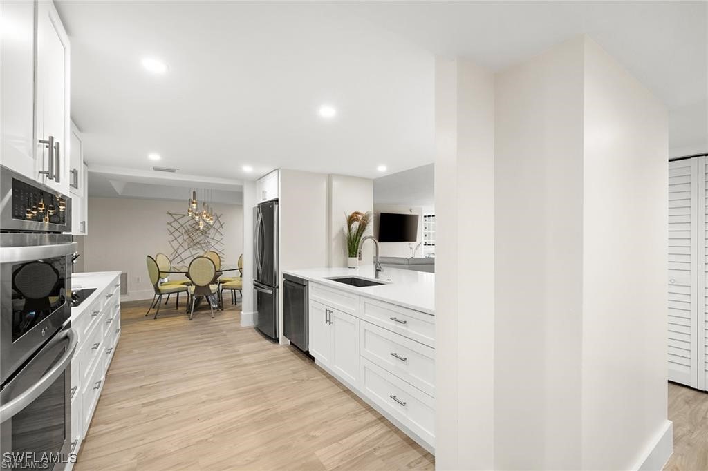 5601 Turtle Bay Drive, Unit 302 Naples, FL 34108 - Photo 11 of 44 a kitchen with stainless steel appliances kitchen island sink stove and cabinets