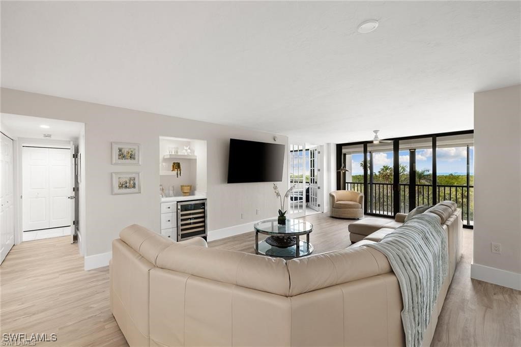 5601 Turtle Bay Drive, Unit 302 Naples, FL 34108 - Photo 13 of 44 a living room with furniture wooden floor and a flat screen tv