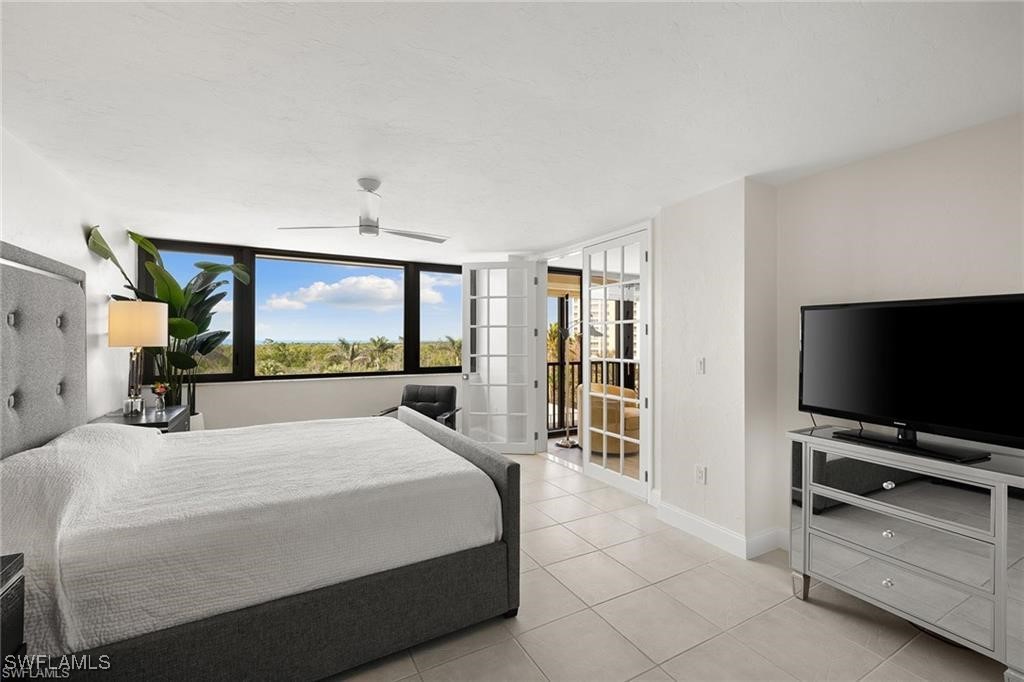 5601 Turtle Bay Drive, Unit 302 Naples, FL 34108 - Photo 17 of 44 a bedroom with a bed and a flat screen tv