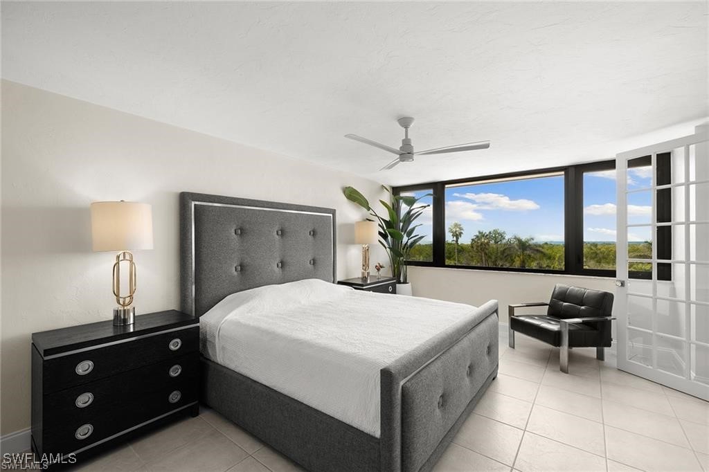 5601 Turtle Bay Drive, Unit 302 Naples, FL 34108 - Photo 18 of 44 a spacious bedroom with a bed and a large window