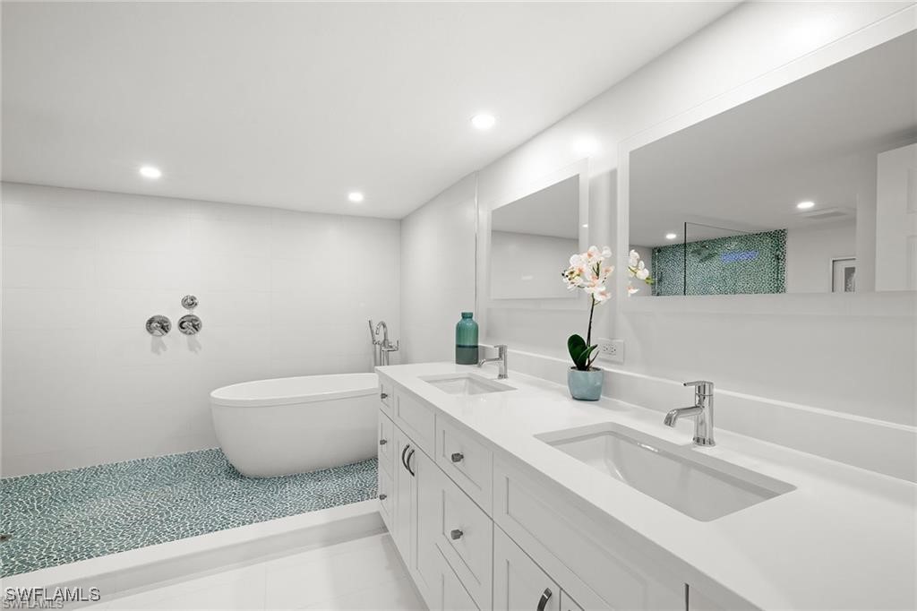 5601 Turtle Bay Drive, Unit 302 Naples, FL 34108 - Photo 20 of 44 a bathroom with a double vanity sink and a bathtub