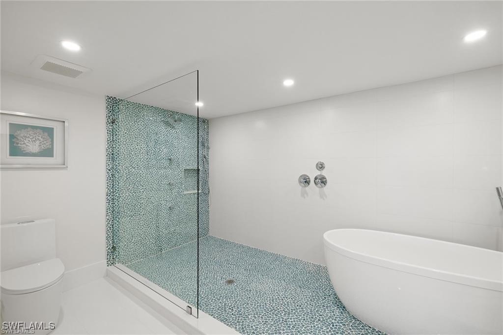 5601 Turtle Bay Drive, Unit 302 Naples, FL 34108 - Photo 22 of 44 a bathroom with a shower a toilet and sink