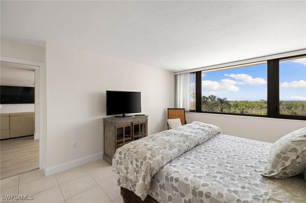 5601 Turtle Bay Drive, Unit 302 Naples, FL 34108 - Photo 23 of 44 a bedroom with a bed and a flat screen tv