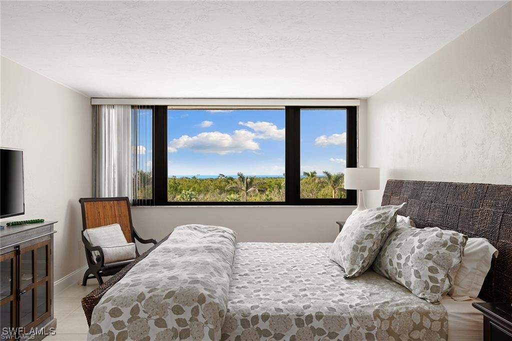 5601 Turtle Bay Drive, Unit 302 Naples, FL 34108 - Photo 24 of 44 a living room with furniture and a flat screen tv