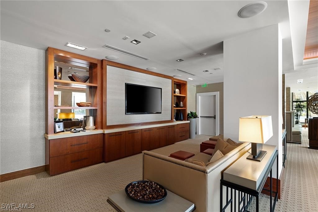 5601 Turtle Bay Drive, Unit 302 Naples, FL 34108 - Photo 31 of 44 a living room with furniture and a flat screen tv