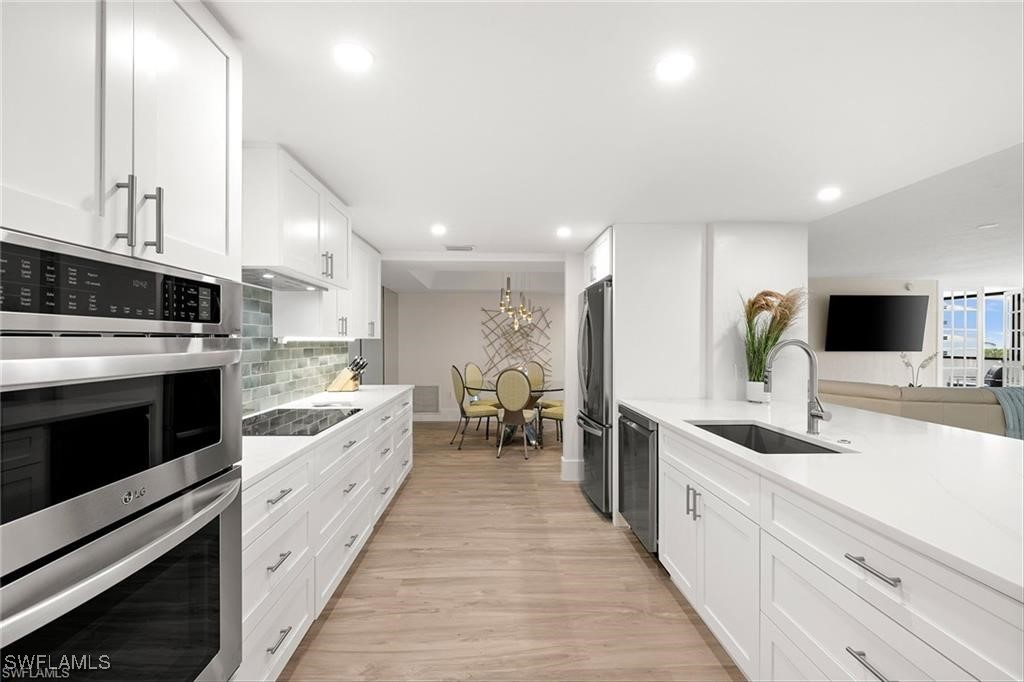 5601 Turtle Bay Drive, Unit 302 Naples, FL 34108 - Photo 5 of 44 a large kitchen with stainless steel appliances kitchen island granite countertop a large counter top and a stove top oven
