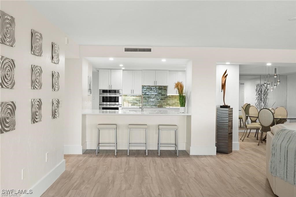 5601 Turtle Bay Drive, Unit 302 Naples, FL 34108 - Photo 6 of 44 a kitchen with stainless steel appliances granite countertop a refrigerator and microwave