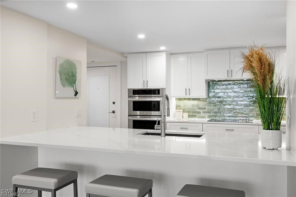 5601 Turtle Bay Drive, Unit 302 Naples, FL 34108 - Photo 7 of 44 a kitchen with a refrigerator and a more cabinets