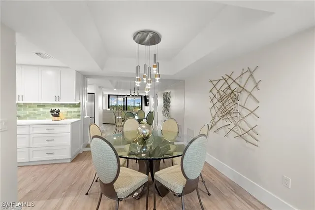 a kitchen with stainless steel appliances granite countertop a table chairs in it and wooden floors