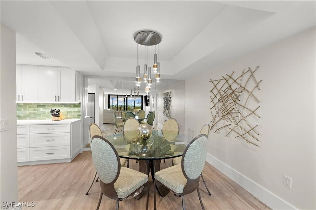 5601 Turtle Bay Drive, Unit 302 Naples, FL 34108 - Photo 9 of 44 a view of a dining room with furniture and chandelier