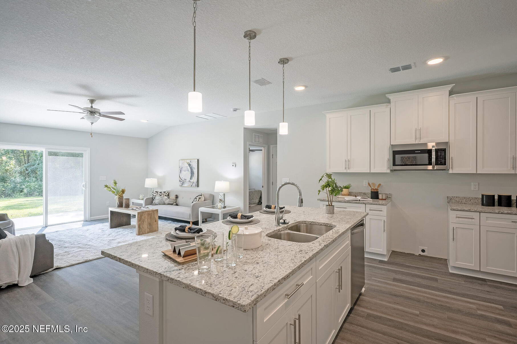 8768 Orme Road Jacksonville, FL 32220 - Photo 23 of 36 a kitchen with kitchen island granite countertop a sink counter top space appliances and cabinets