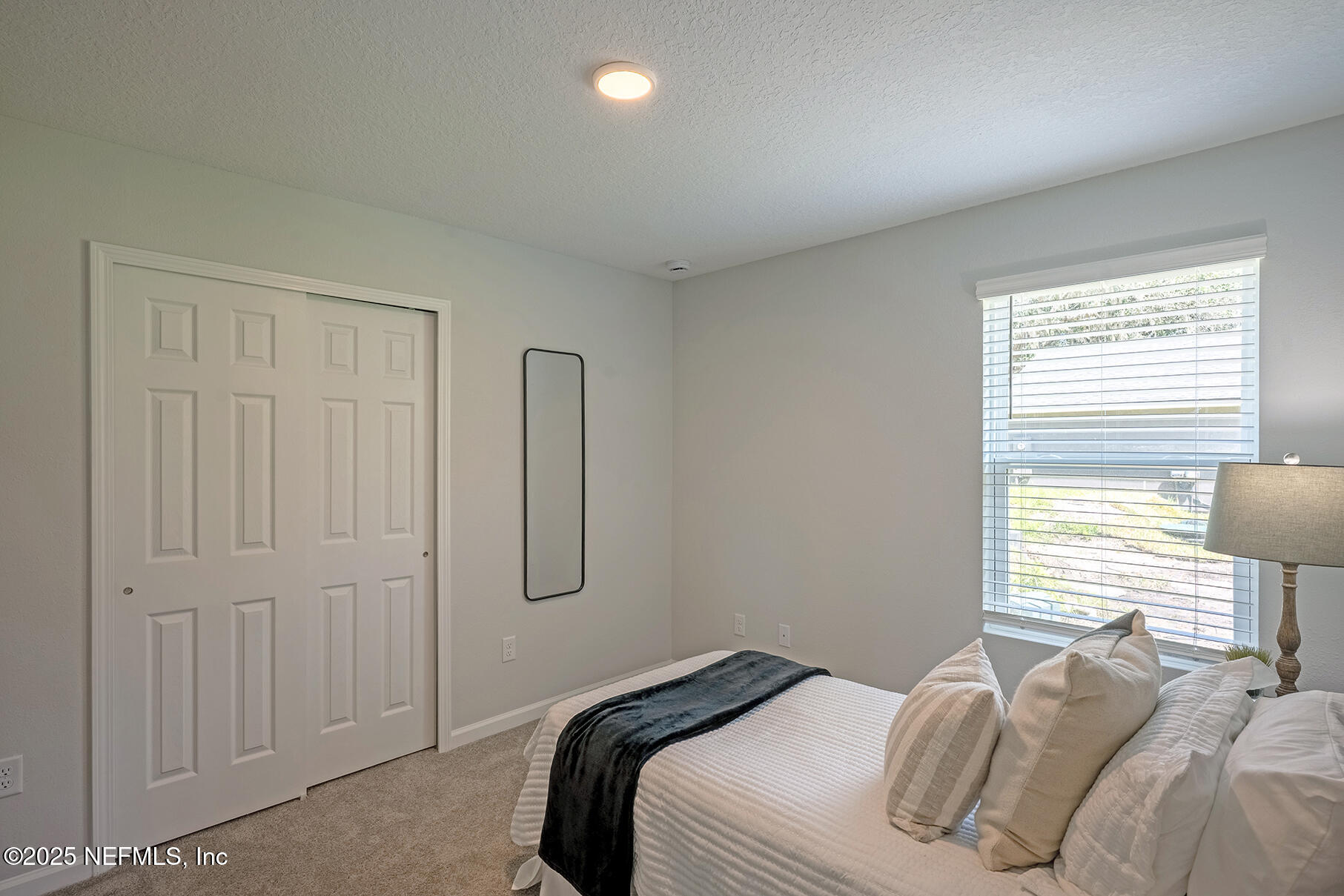 8768 Orme Road Jacksonville, FL 32220 - Photo 4 of 36 a bedroom with a bed and a lamp