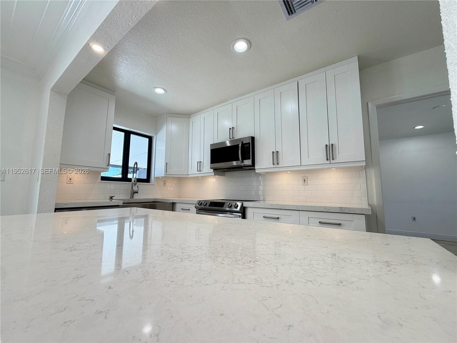 16320 Southwest 278th Street Homestead, FL 33031 - Photo 12 of 69 a large kitchen with granite countertop a sink and a stove top oven