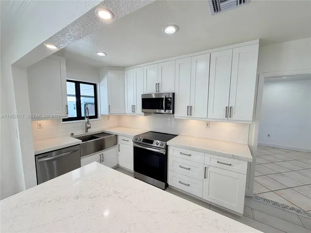 a kitchen with refrigerator cabinets and wooden floor