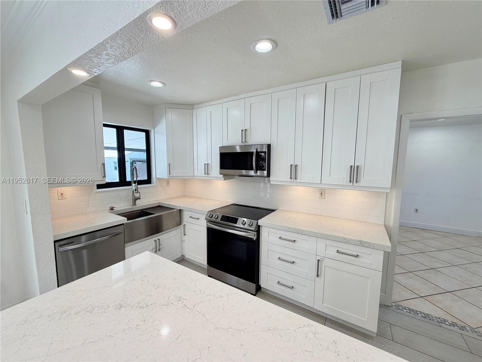 16320 Southwest 278th Street Homestead, FL 33031 - Photo 13 of 69 a kitchen with granite countertop white cabinets and stainless steel appliances