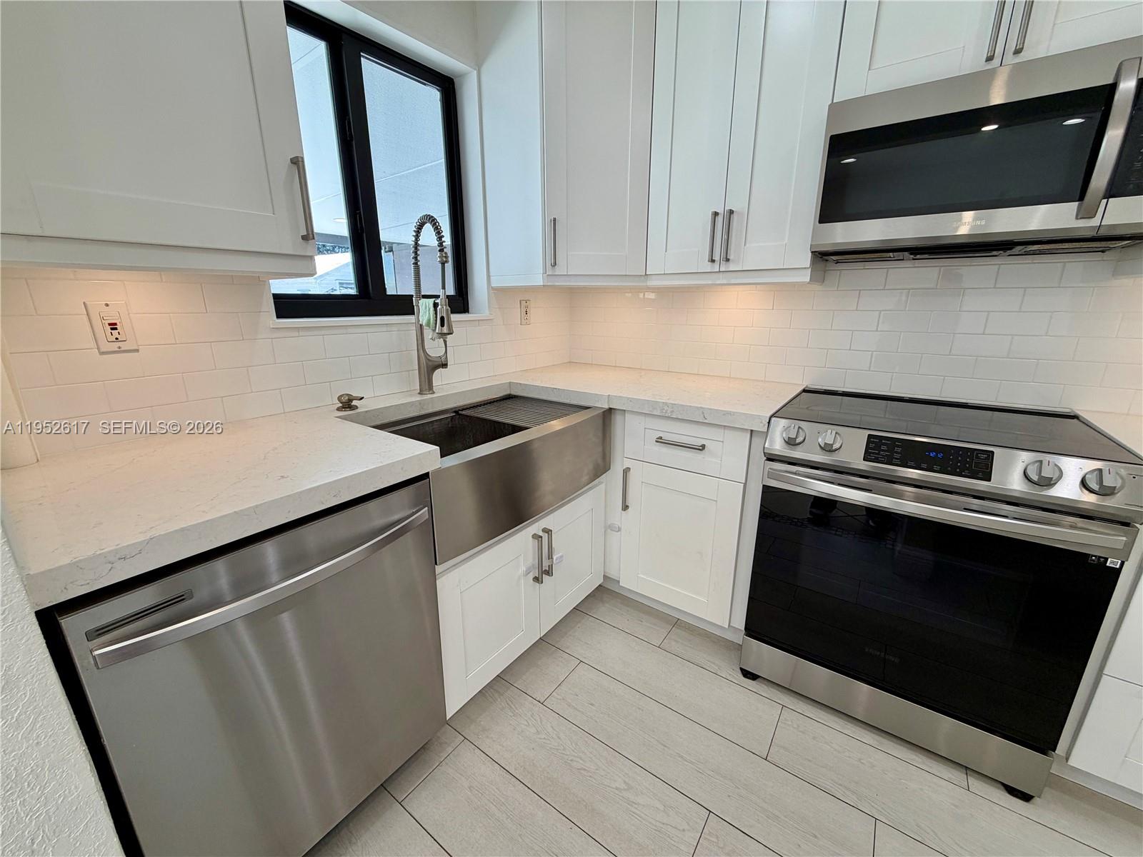 16320 Southwest 278th Street Homestead, FL 33031 - Photo 15 of 69 a kitchen with stainless steel appliances granite countertop a sink stove and microwave