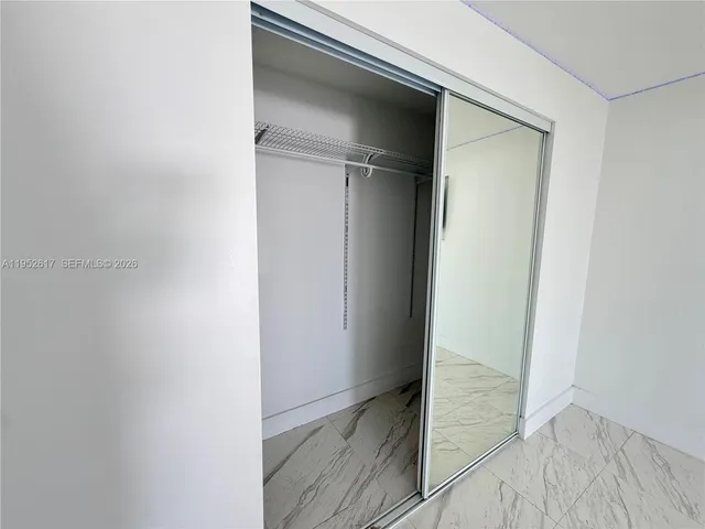 a view of a hallway to a livingroom with furniture