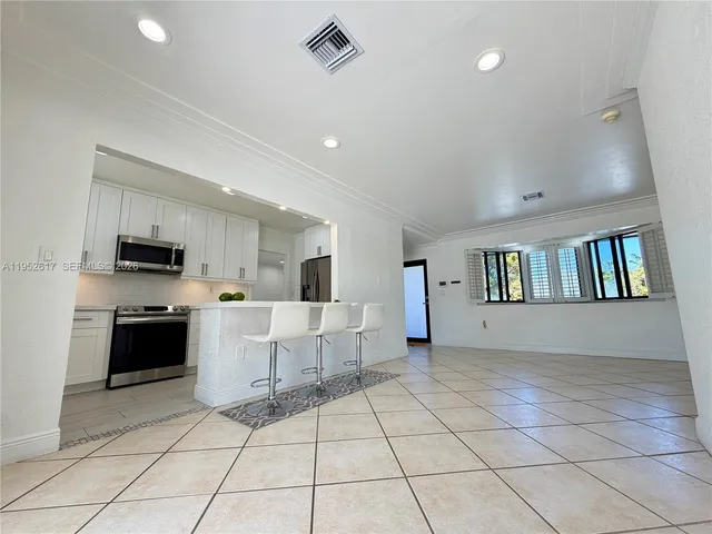 a large kitchen with granite countertop a sink and a stove top oven