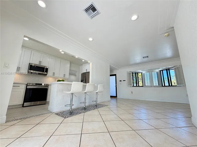 a kitchen with granite countertop white cabinets and stainless steel appliances
