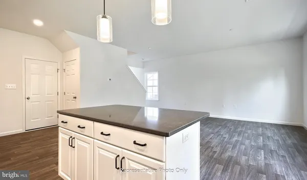 a kitchen with kitchen island white cabinets and wooden floor