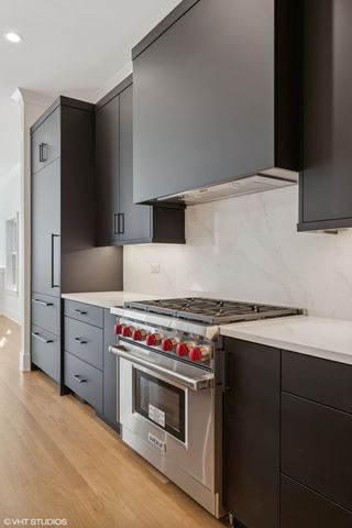 a kitchen with stainless steel appliances granite countertop a sink a stove and a refrigerator