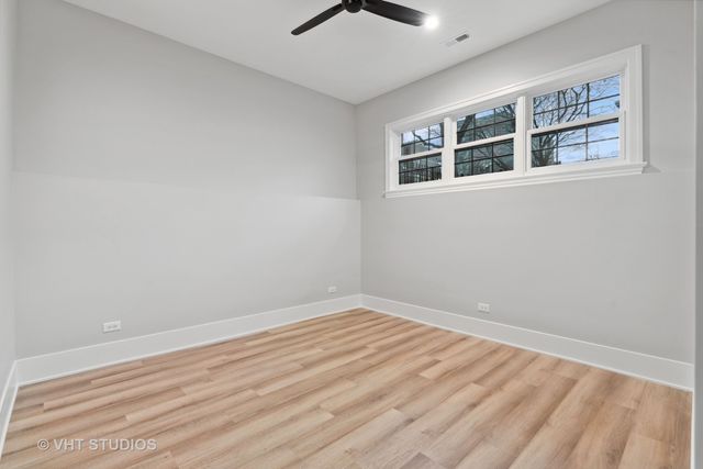 a view of empty room with wooden floor and windows