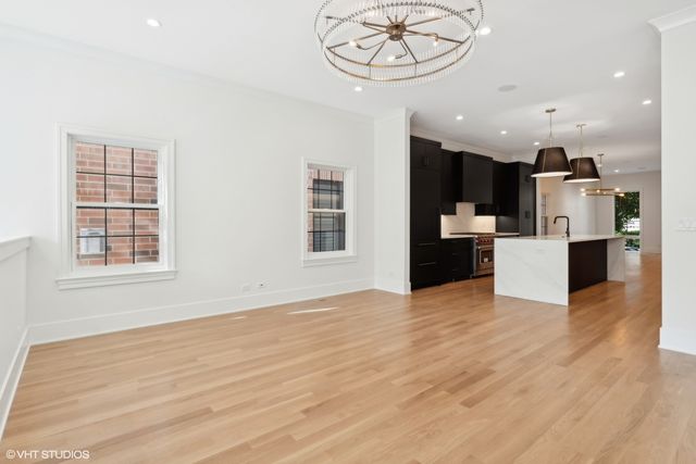 a view of a kitchen with kitchen island a counter top space appliances and a ceiling fan