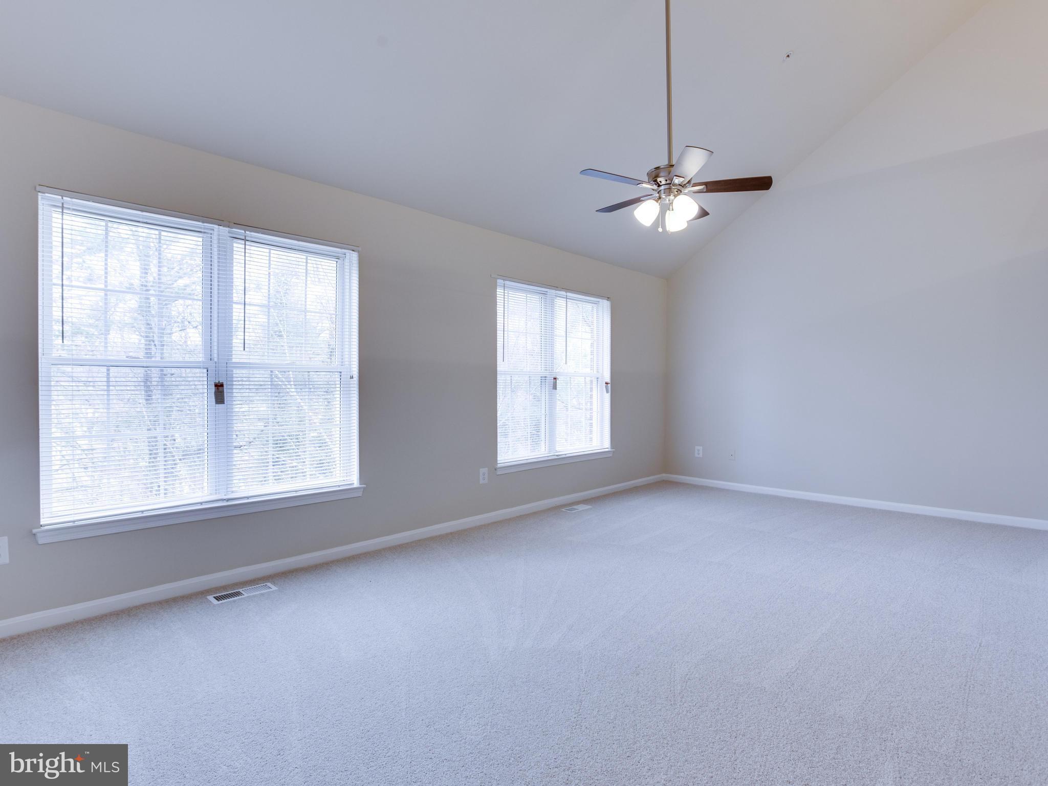 9320 Ispahan Loop Laurel, MD 20708 - Photo 24 of 30 en empty room with windows and ceiling fan