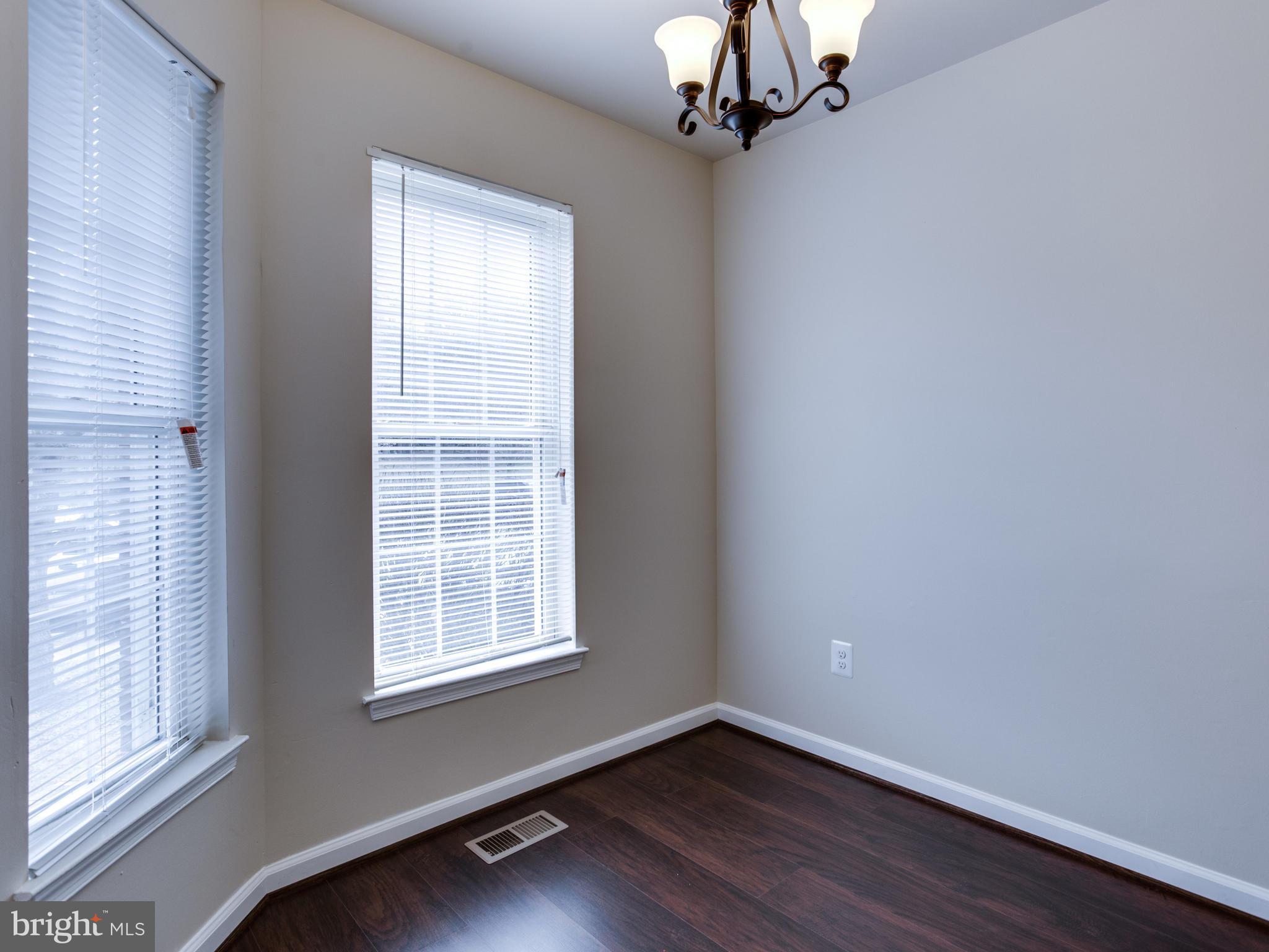 9320 Ispahan Loop Laurel, MD 20708 - Photo 4 of 30 a view of an empty room with wooden floor and a window