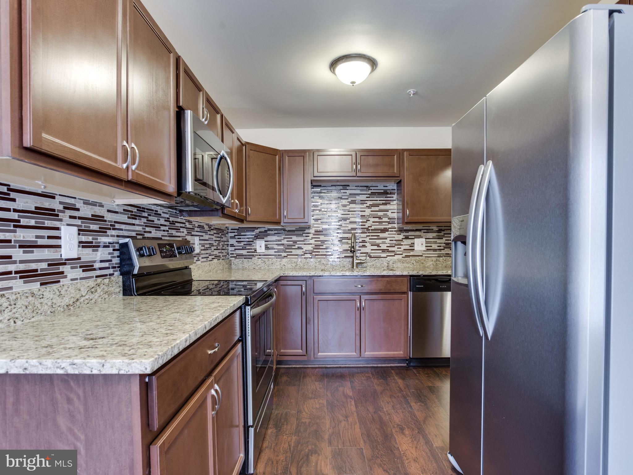 9320 Ispahan Loop Laurel, MD 20708 - Photo 6 of 30 a kitchen with stainless steel appliances granite countertop a sink refrigerator and cabinets