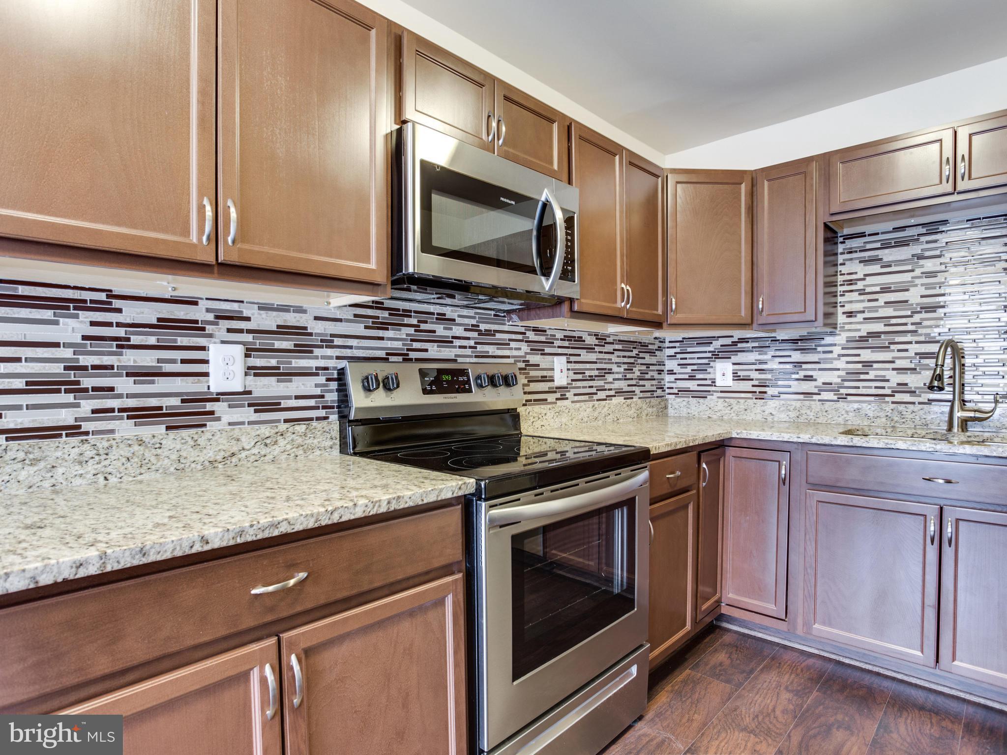 9320 Ispahan Loop Laurel, MD 20708 - Photo 7 of 30 a kitchen with stainless steel appliances granite countertop a sink stove and microwave