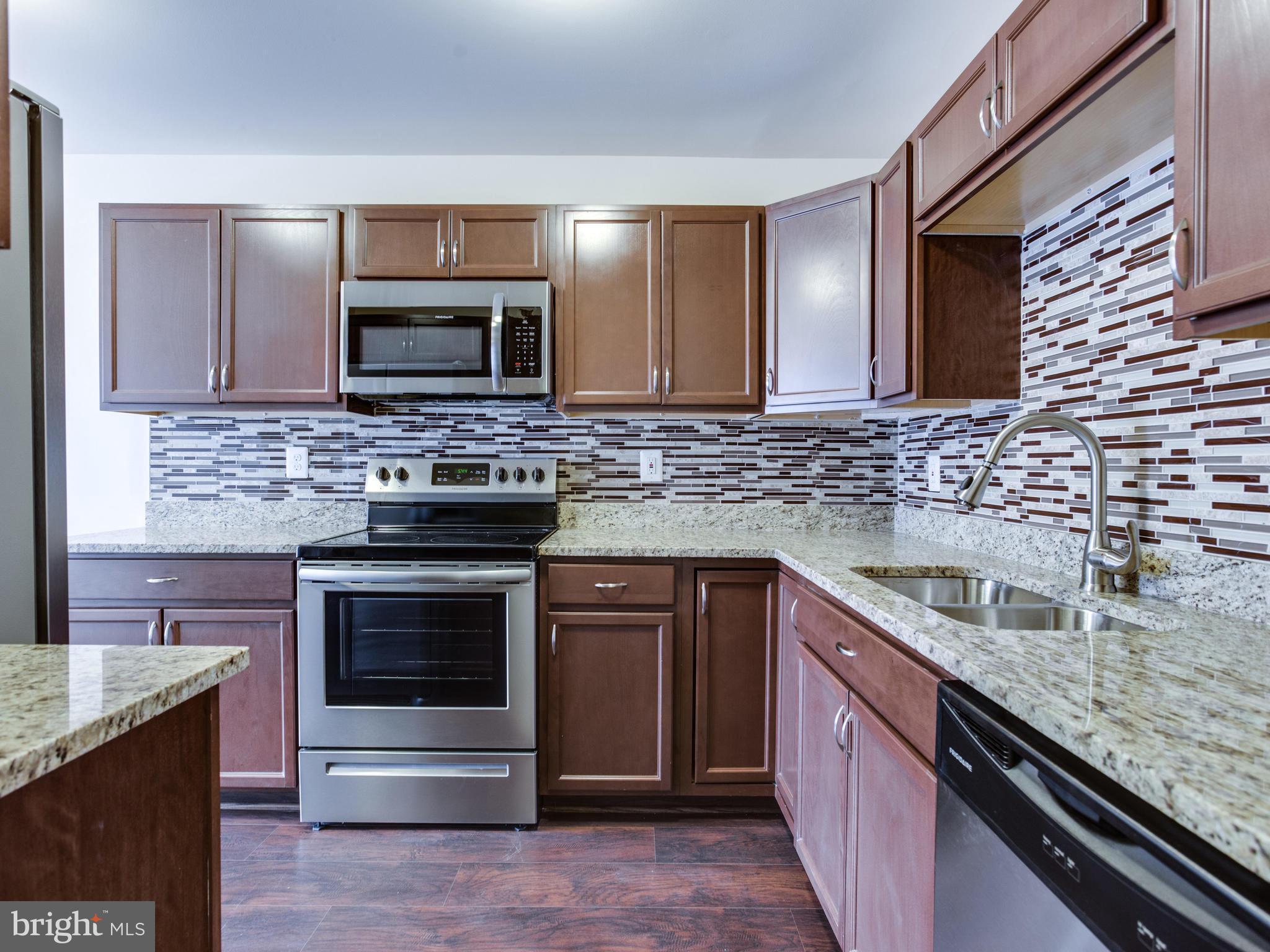 9320 Ispahan Loop Laurel, MD 20708 - Photo 8 of 30 a kitchen with stainless steel appliances granite countertop a sink stove and refrigerator