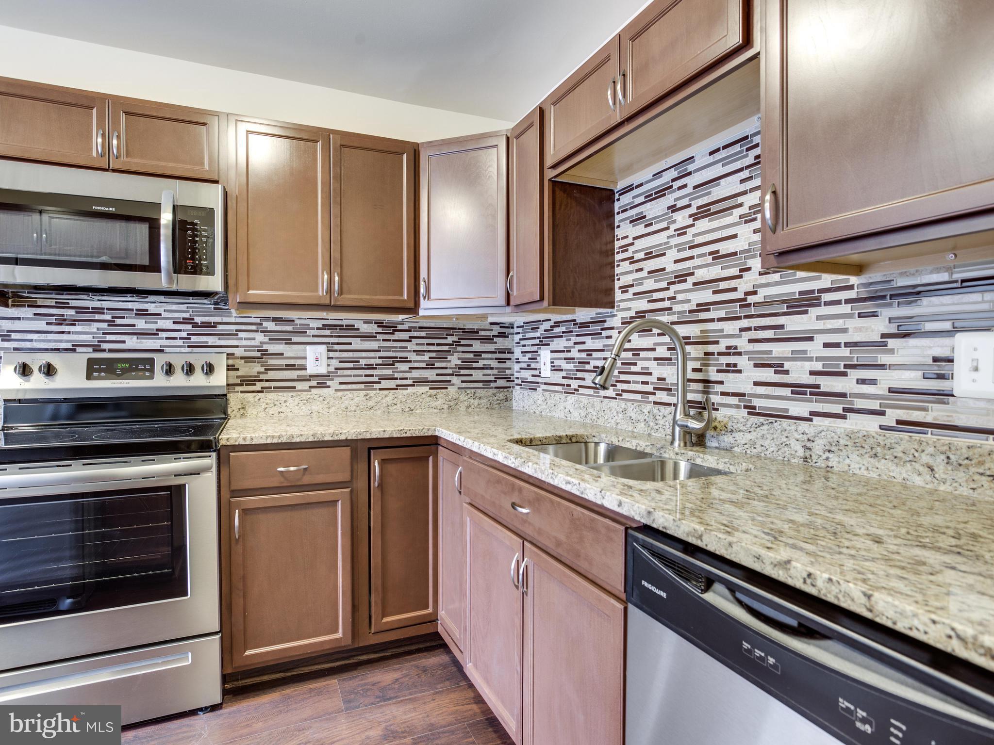 9320 Ispahan Loop Laurel, MD 20708 - Photo 9 of 30 a kitchen with stainless steel appliances granite countertop a sink stove and microwave