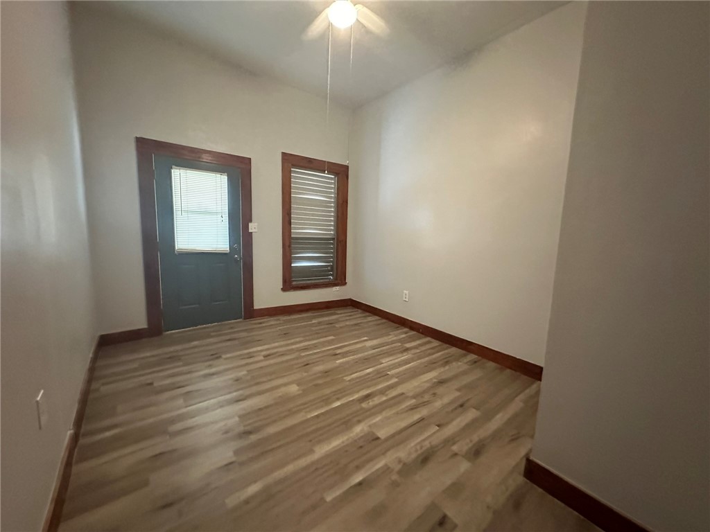 221 Commerce Street, Unit E Portland, TX 78374 - Photo 13 of 26 a view of an empty room with window and wooden floor