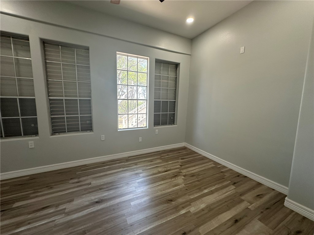 221 Commerce Street, Unit E Portland, TX 78374 - Photo 15 of 26 an empty room with wooden floor and windows