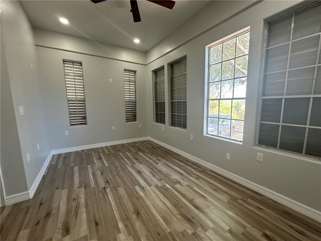 221 Commerce Street, Unit E Portland, TX 78374 - Photo 16 of 26 a view of an empty room with wooden floor and a window