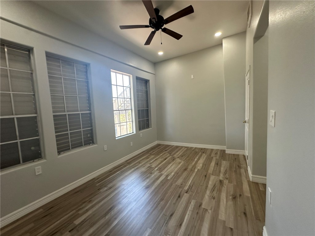 221 Commerce Street, Unit E Portland, TX 78374 - Photo 19 of 26 a view of empty room with wooden floor and fan