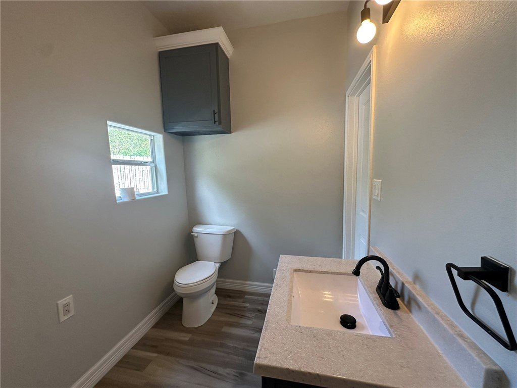 221 Commerce Street, Unit E Portland, TX 78374 - Photo 21 of 26 a bathroom with a sink toilet and a window