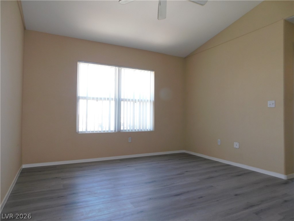 7255 West Sunset Road, Unit 2029 Las Vegas, NV 89113 - Photo 5 of 21 A spacious room featuring a vaulted ceiling and elegant hardwood-style flooring, ready for your personal touch.