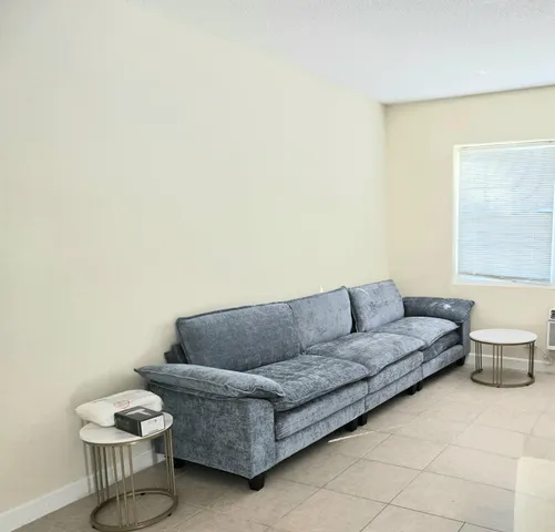 a living room with a couch and a potted plant