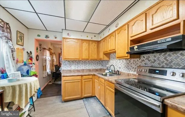 a kitchen with stainless steel appliances sink stove and cabinets